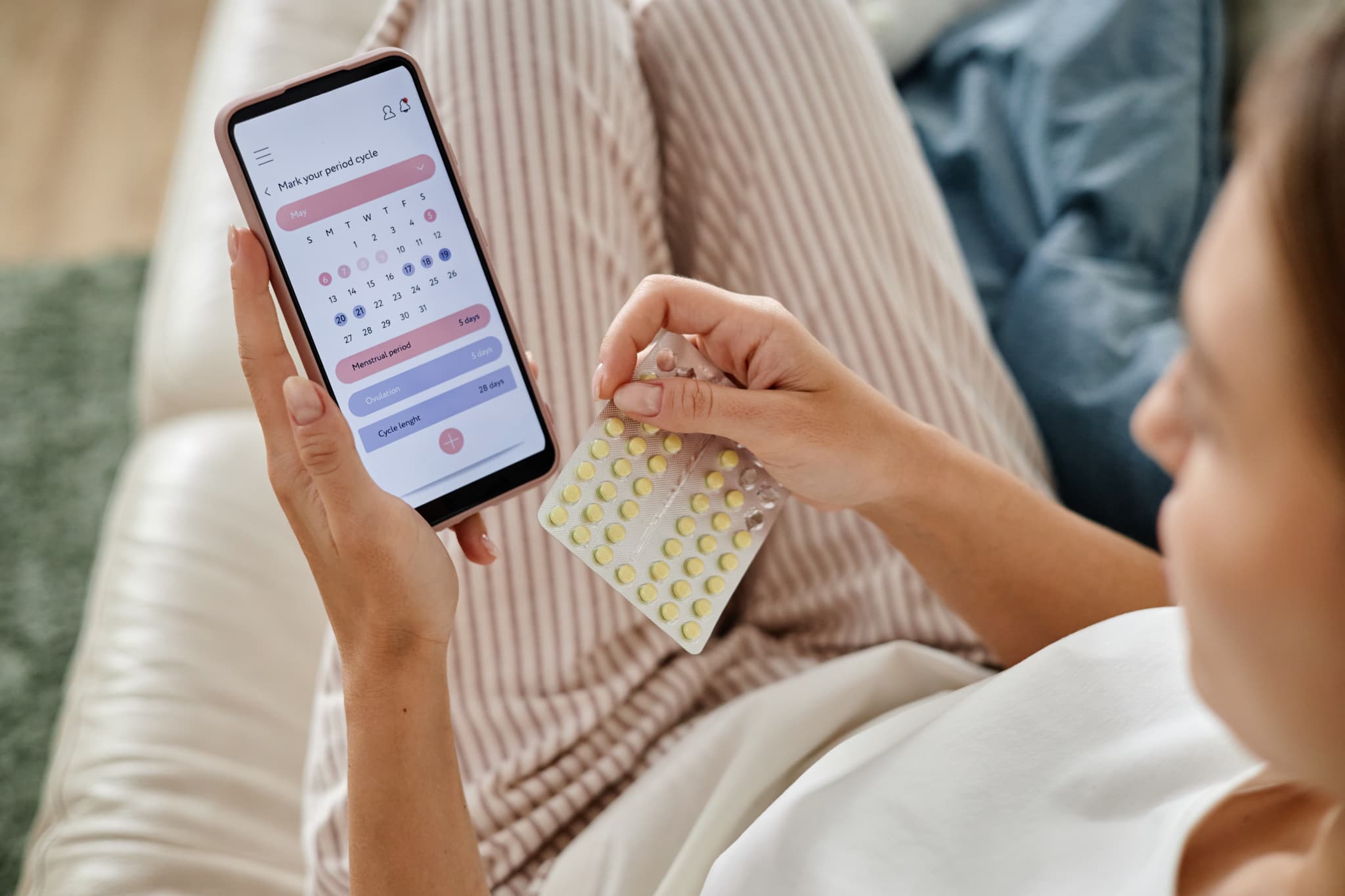 スマホで生理周期と服用日を確認する女性