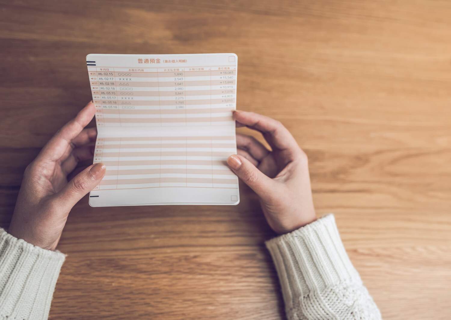 通帳の残高を見て悩む様子