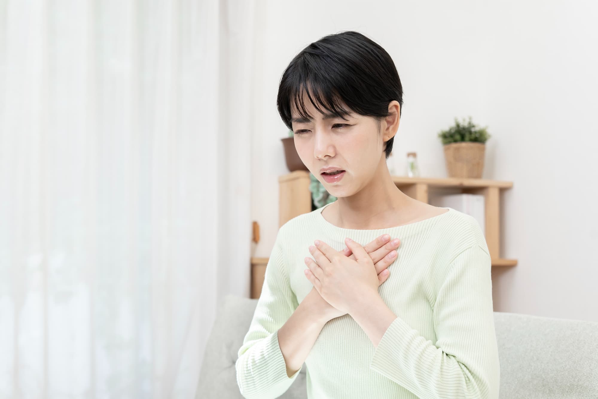 薬の副作用で吐き気を感じる女性
