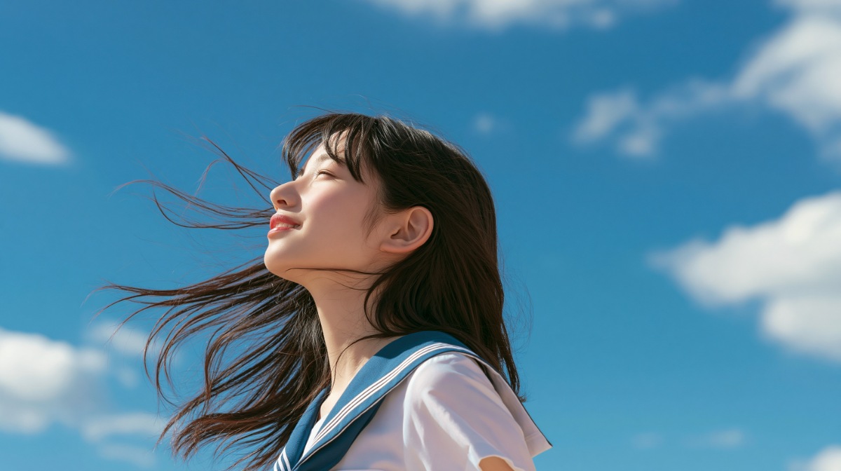 青空の下で目を閉じる10代の制服の少女