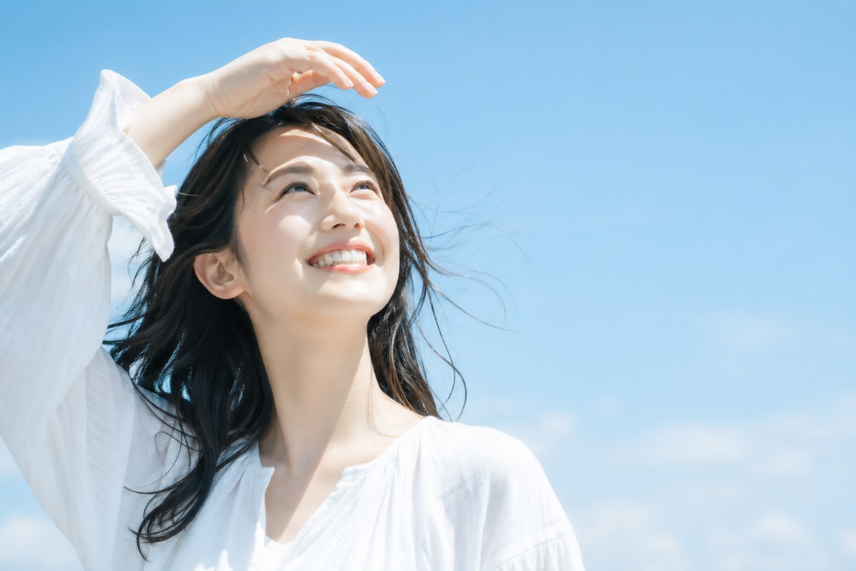 笑顔で空を見上げる女性