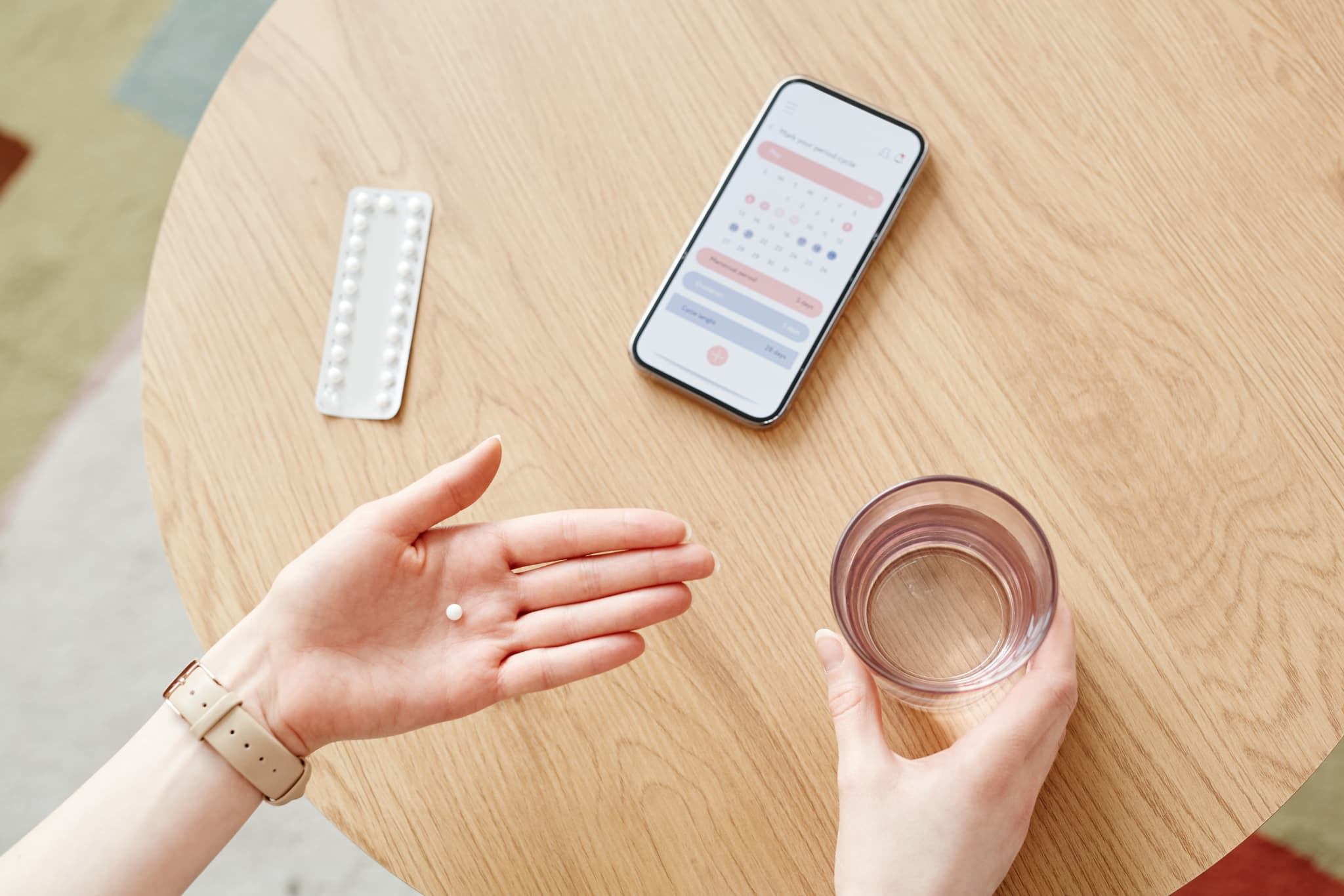 服用開始日を確認しながらピルを飲む女性