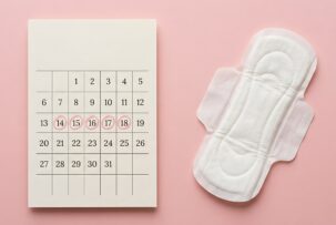生理日にマルの付いた月間カレンダーと生理用ナプキン