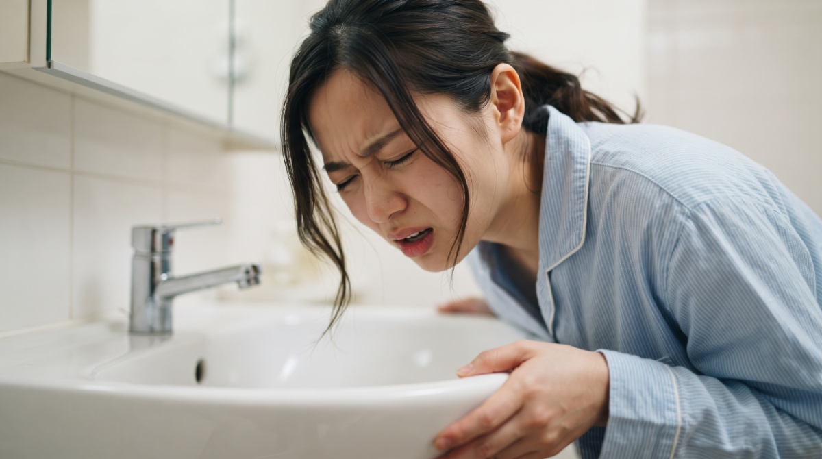 洗面所で吐きそうになっている女性